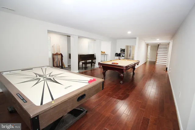 a living room with a table chairs and a wooden floor