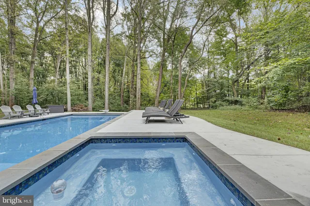 a view of a swimming pool with a patio and garden