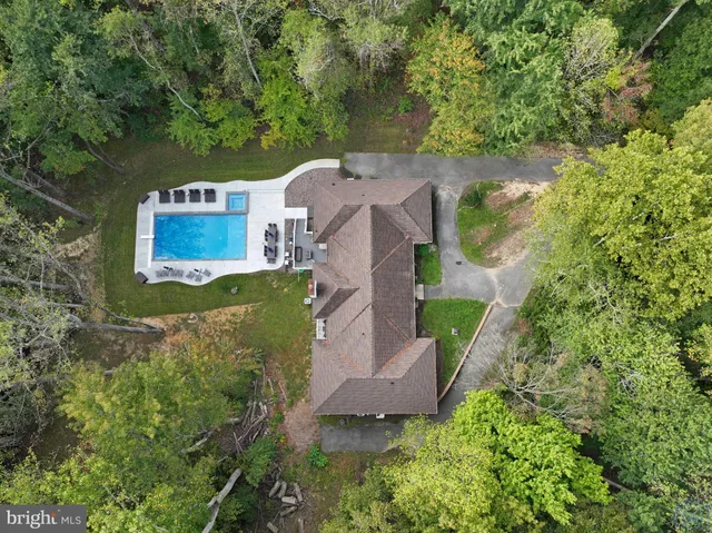 an aerial view of a house with a yard and large trees