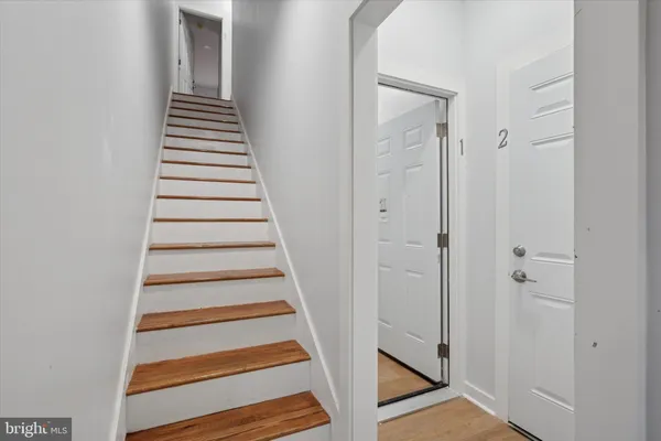 a view of a hallway with wooden floor and entryway