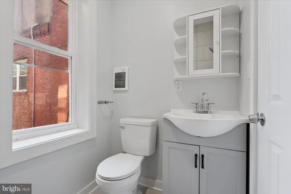 a bathroom with a toilet a sink and a window