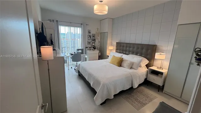 a bed sitting in a bedroom next to a window