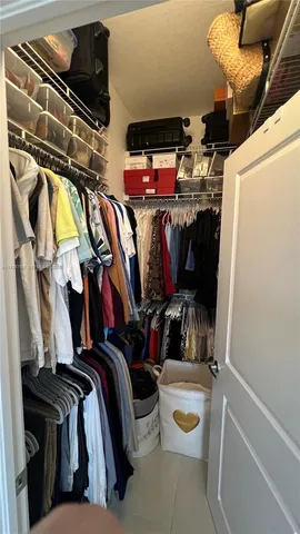 a view of walk in closet with clothes and shoes