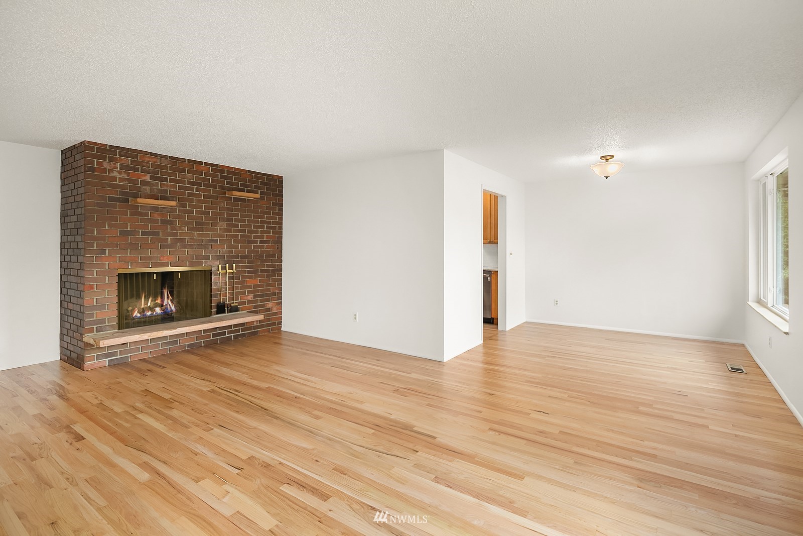 408 Index Place Northeast Renton, WA 98056 - Photo 4 of 31 a view of an empty room with wooden floor fireplace and a window