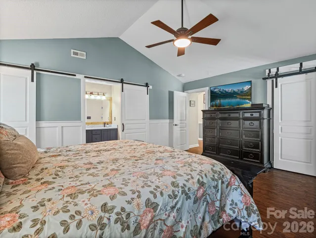 a bedroom with a bed dresser and a flat tv screen