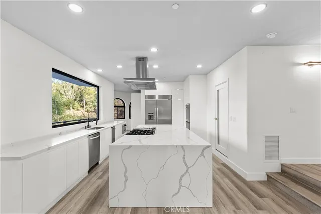 a kitchen with stainless steel appliances granite countertop a stove a sink and a refrigerator