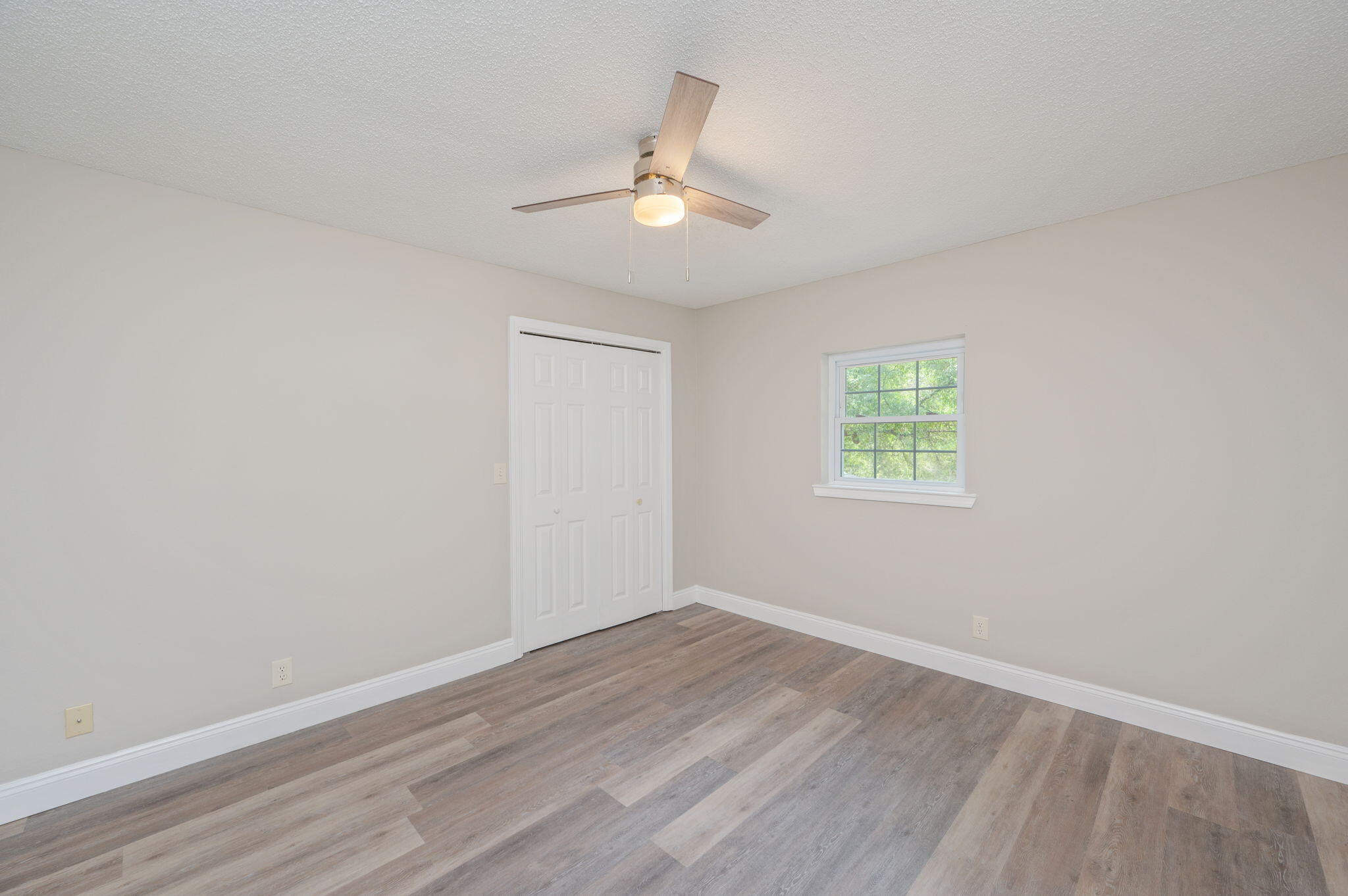 165 Smith Street Crestview, FL 32539 - Photo 15 of 30 an empty room with wooden floor ceiling fan and windows