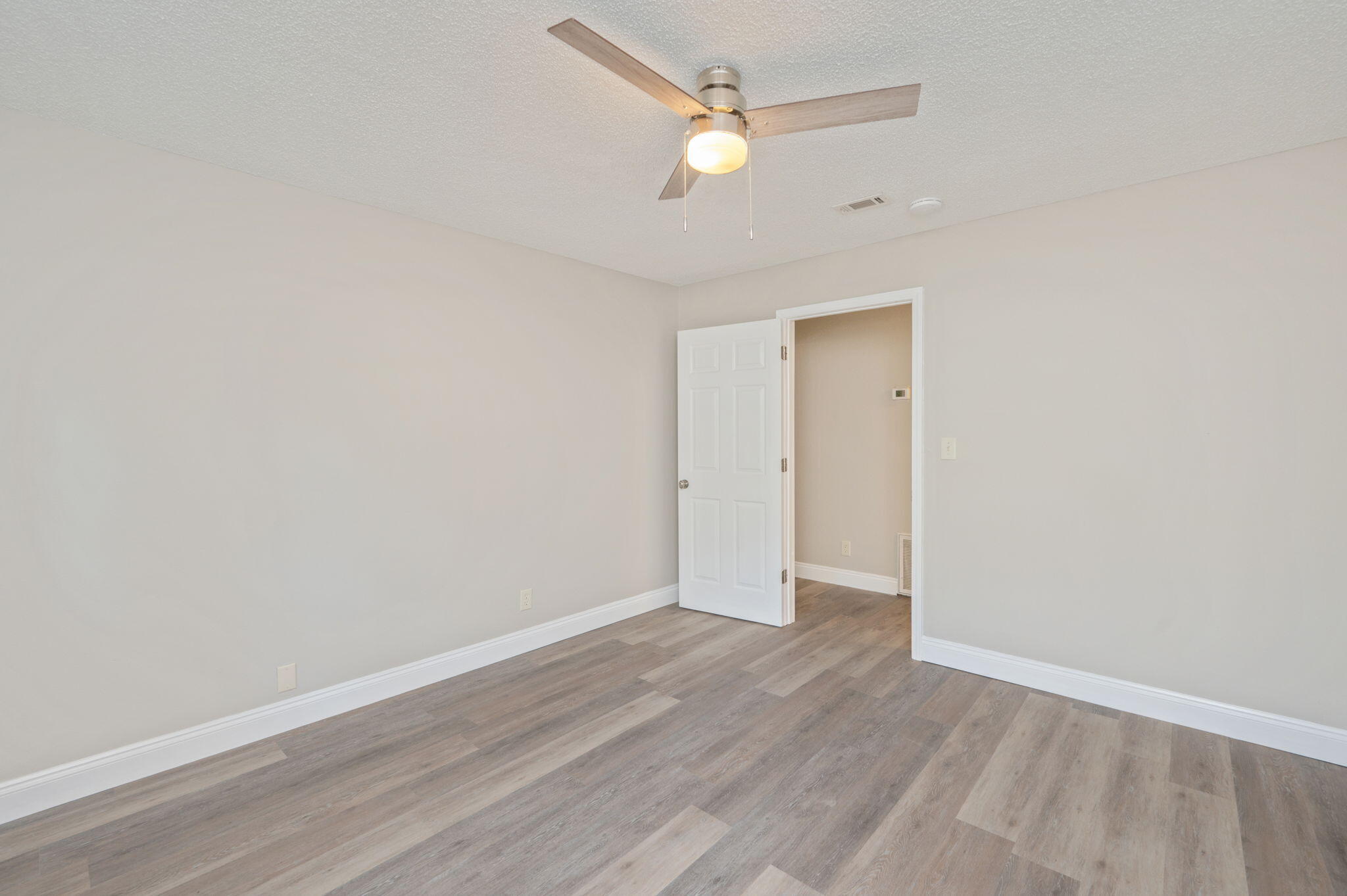 165 Smith Street Crestview, FL 32539 - Photo 16 of 30 an empty room with wooden floor and ceiling fan