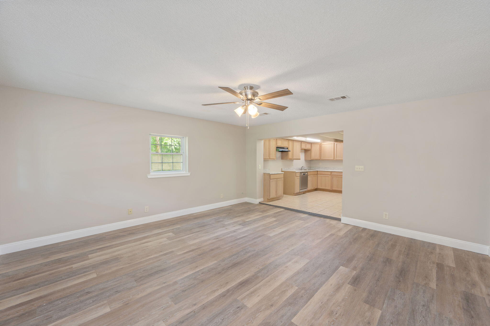 165 Smith Street Crestview, FL 32539 - Photo 5 of 30 a view of an empty room with a window and wooden floor