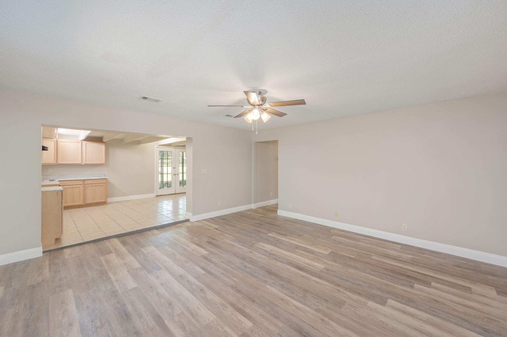 165 Smith Street Crestview, FL 32539 - Photo 6 of 30 a view of an empty room with a window and wooden floor