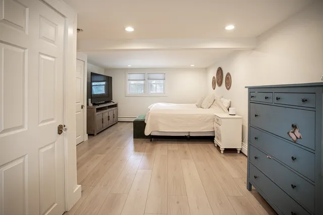 a bedroom with a bed and wooden floor