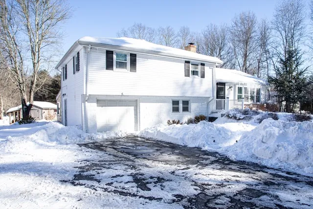 a front view of a house with a yard covered in snow