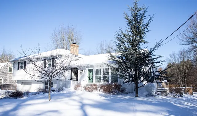 a roof deck with table and chairs under an umbrella