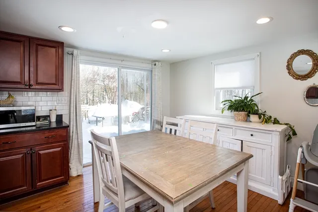 a kitchen with a stove a sink a refrigerator a stove a dining table and chairs