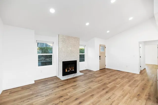 a living room with stainless steel appliances kitchen island granite countertop a sink cabinets and wooden floor