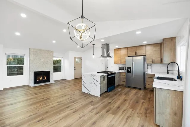 a kitchen with stainless steel appliances granite countertop a refrigerator and a sink