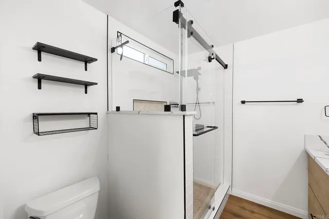 a view of a big room with wooden floor and windows