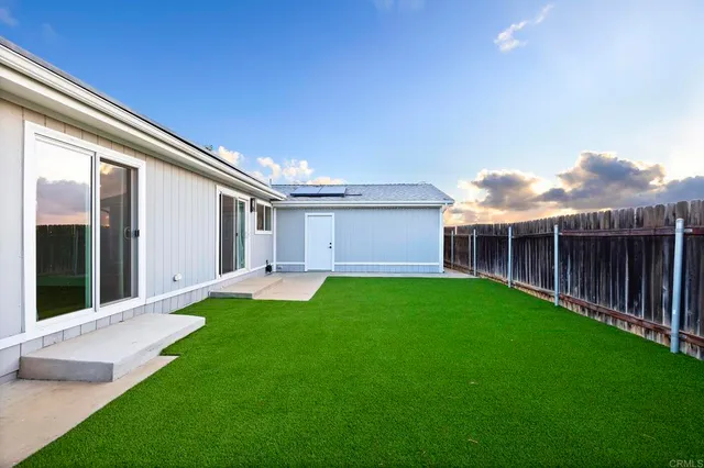 a aerial view of a house with a yard and lake view