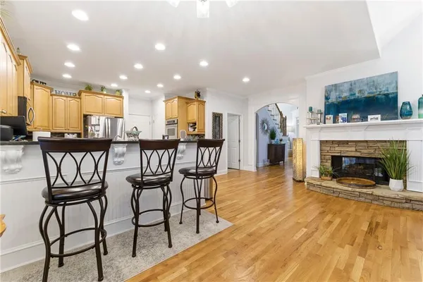 a living room with furniture and a flat screen tv with kitchen view