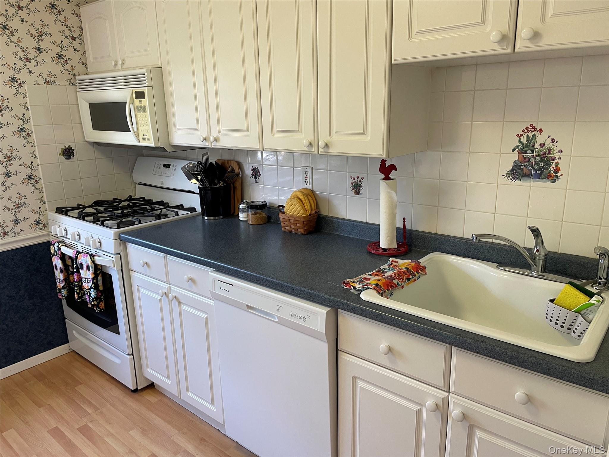 107 Mariners Way Copiague, NY 11726 - Photo 13 of 27 a kitchen with stainless steel appliances granite countertop a sink stove and cabinets