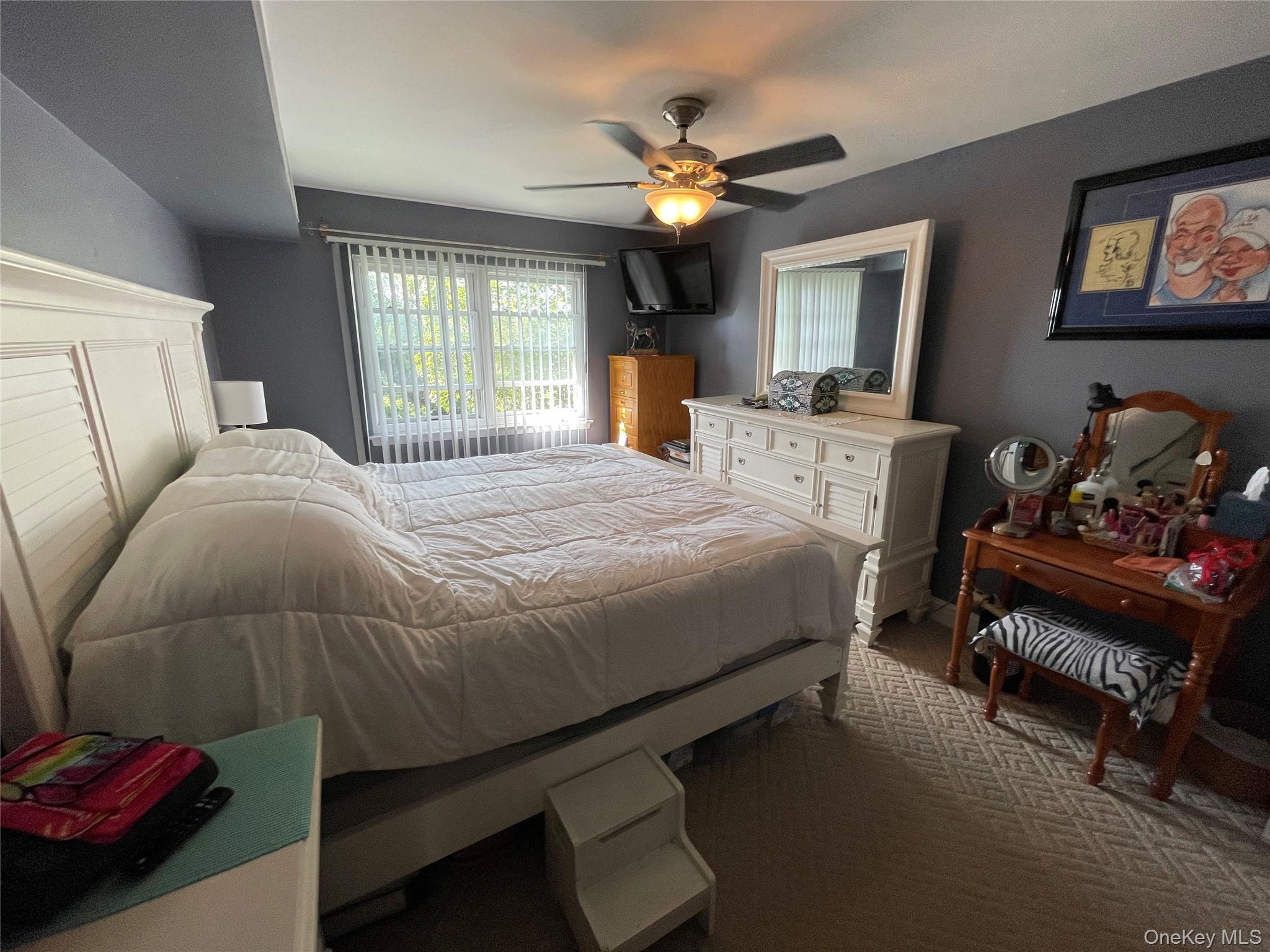 107 Mariners Way Copiague, NY 11726 - Photo 19 of 27 a bedroom with a bed and a chandelier