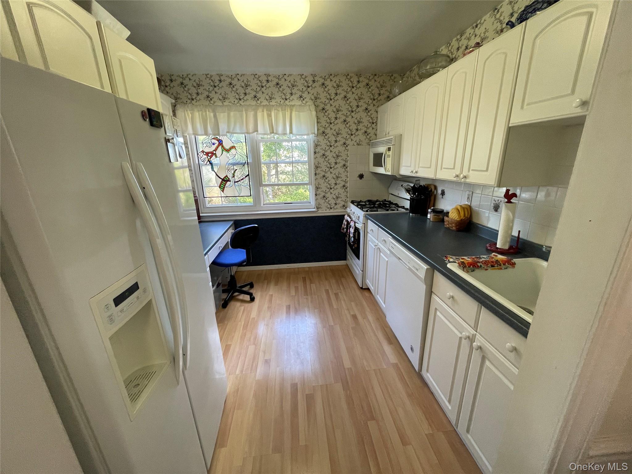 107 Mariners Way Copiague, NY 11726 - Photo 10 of 27 a kitchen with granite countertop a refrigerator a sink a stove a refrigerator and wooden floor