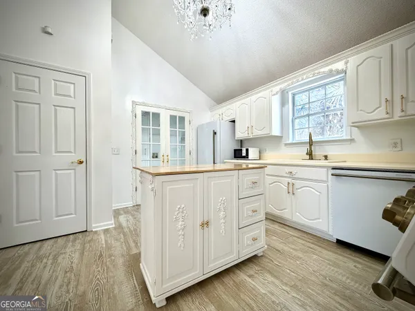 a kitchen with white cabinets and sink