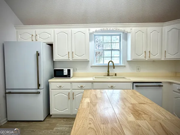 a kitchen with white cabinets and refrigerator