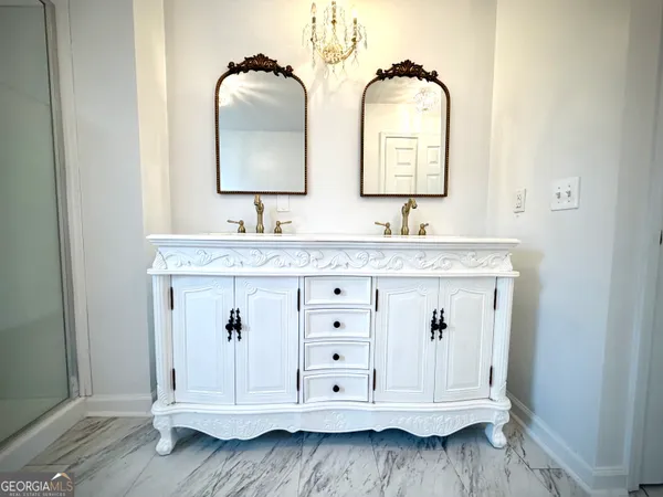 a bathroom with double vanity and a mirror