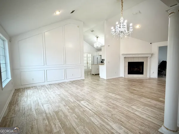 wooden floor chandelier and windows in a room