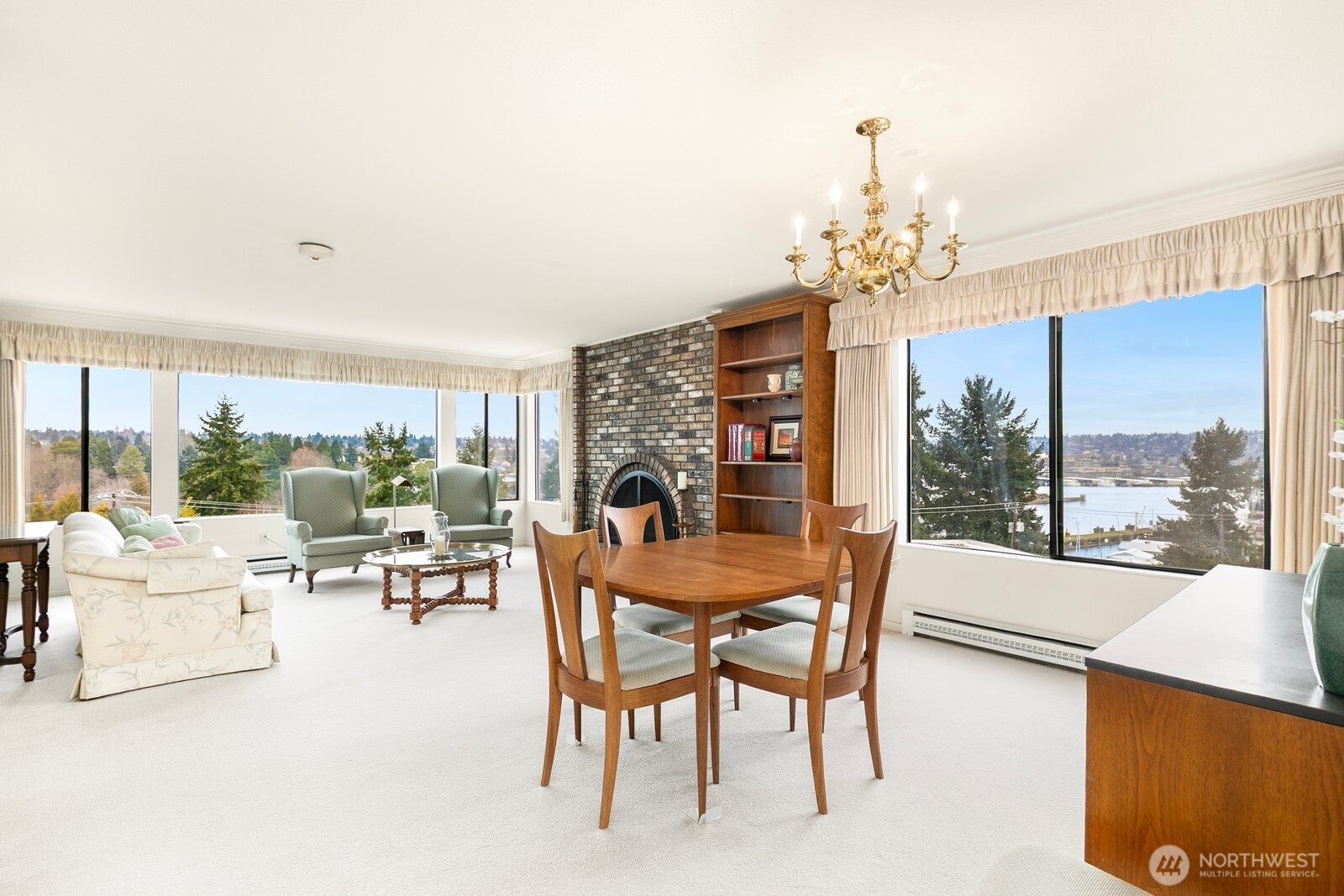 3113 West Harley Street, Unit 3115 Seattle, WA 98199 - Photo 10 of 28 a dining room with furniture a chandelier and large windows