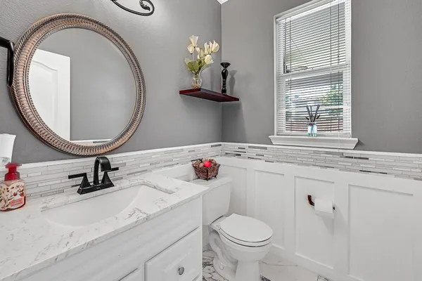 a bathroom with a sink a toilet and a mirror