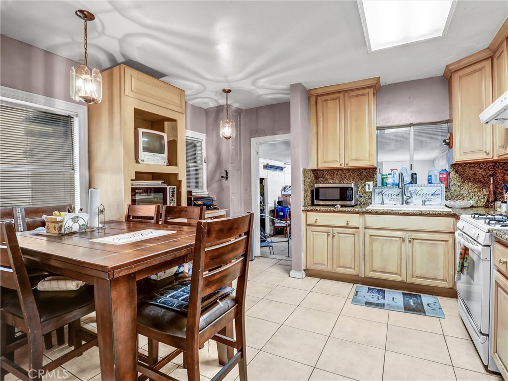 405 South Ward Avenue Compton, CA 90221 - Photo 18 of 28 a kitchen with stainless steel appliances granite countertop a stove a sink dishwasher a dining table and chairs with wooden floor