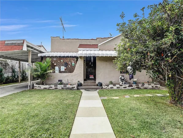 a front view of a house with a garden and yard