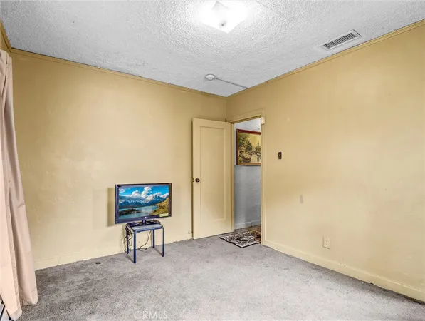 a view of an empty room with furniture and a window