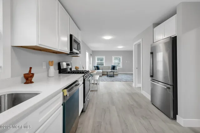 a kitchen with stainless steel appliances a refrigerator sink and cabinets