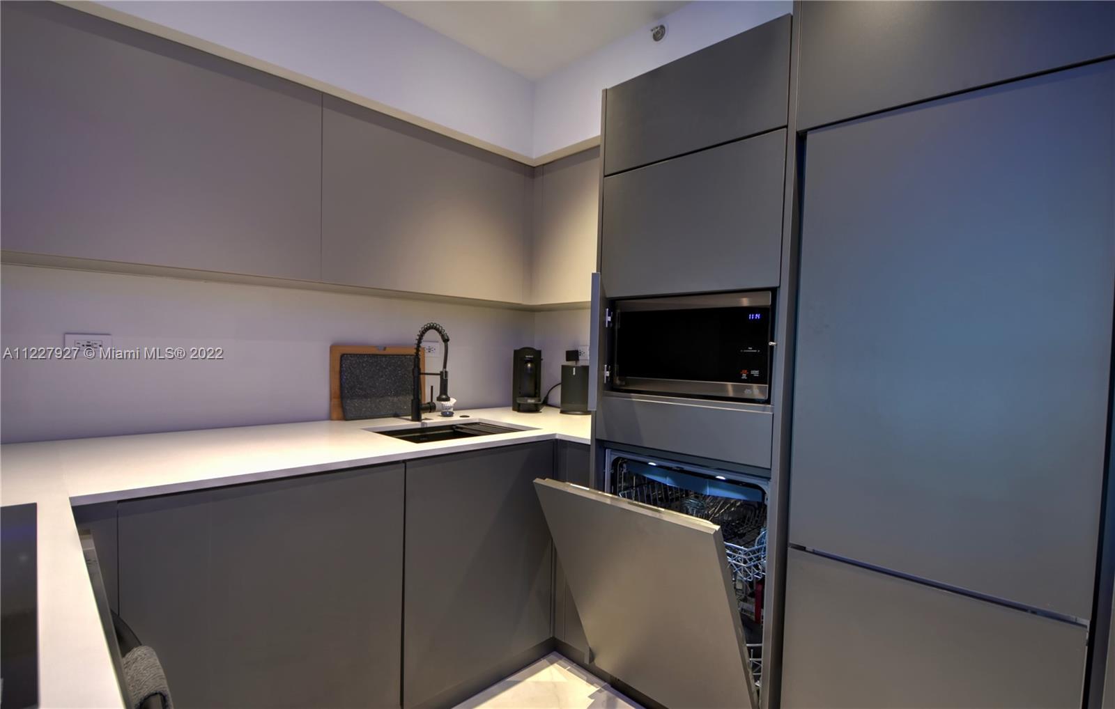 1500 Bay Road, Unit 364S Miami Beach, FL 33139 - Photo 10 of 28 a kitchen with stainless steel appliances a refrigerator and a stove top oven