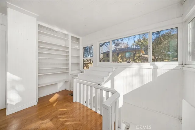 a view of a house with a large window and wooden fence