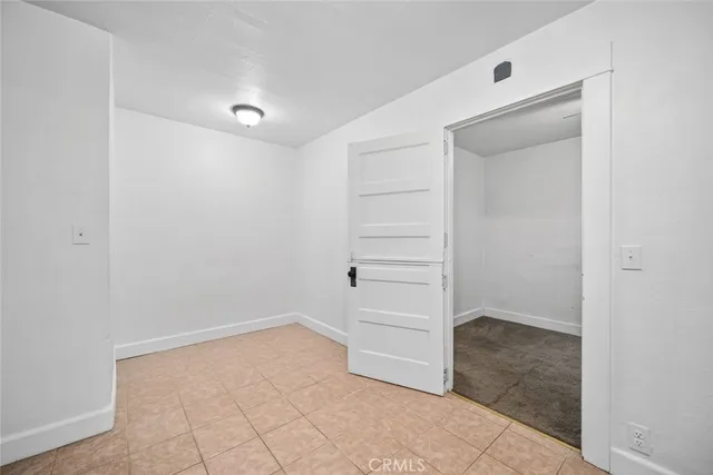 a backyard of a house with wooden fence and large trees