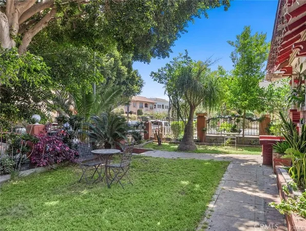 a front view of a house with garden and sitting area