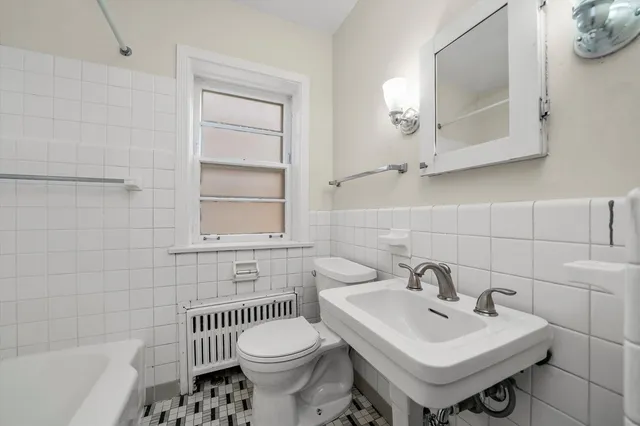 a bathroom with a sink toilet a mirror and bathtub