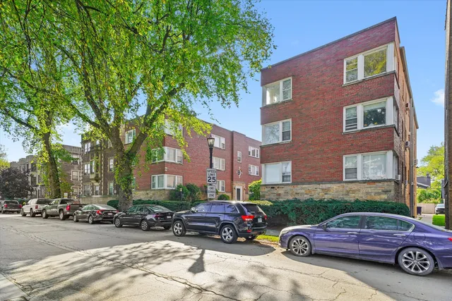 a front view of a building with cars parked