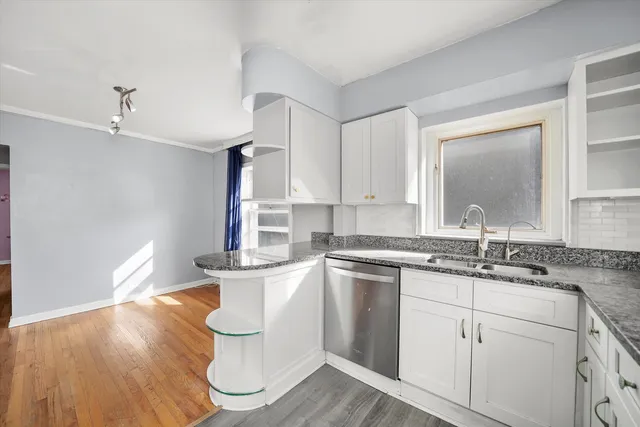 a kitchen with a sink cabinets and wooden floor