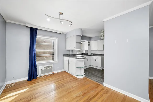 a kitchen with a refrigerator and white cabinets
