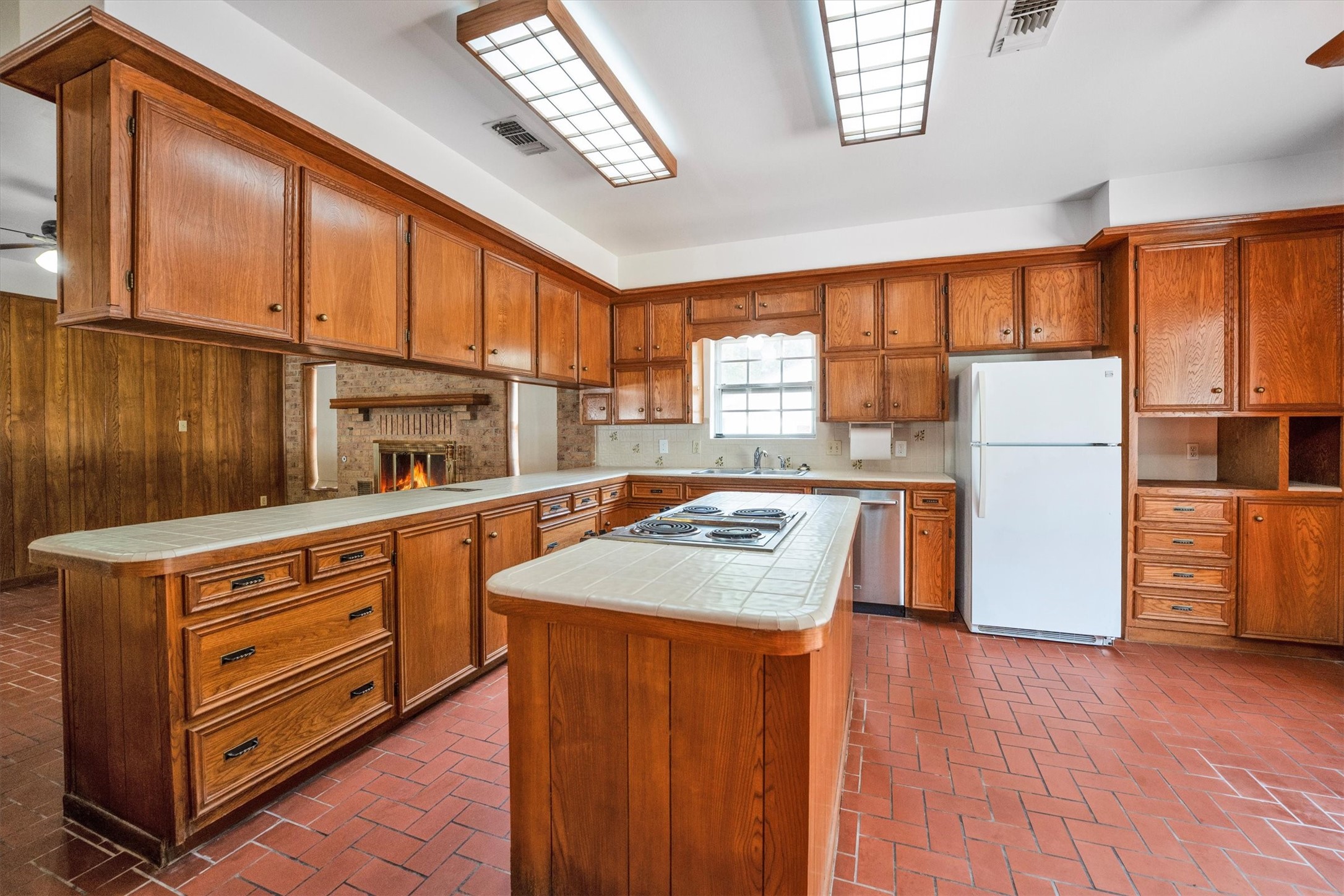 1417 15th Street Huntsville, TX 77340 - Photo 25 of 45 a kitchen with a refrigerator a stove a sink dishwasher and wooden cabinets with wooden floor