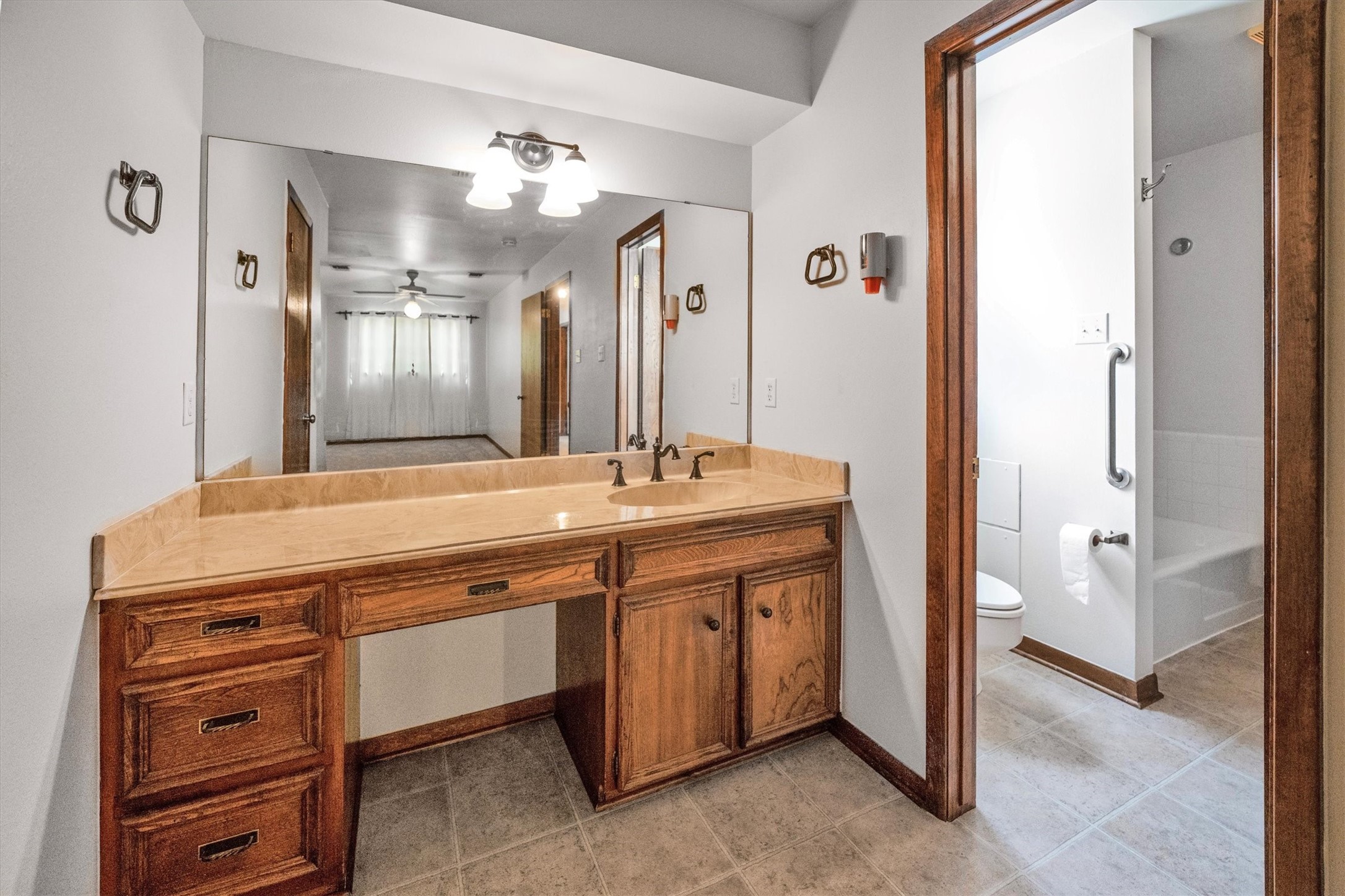 1417 15th Street Huntsville, TX 77340 - Photo 35 of 45 a spacious bathroom with a granite countertop sink a mirror and a