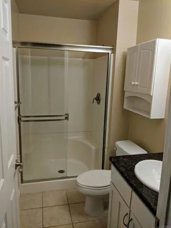 a bathroom with a granite countertop sink toilet and shower