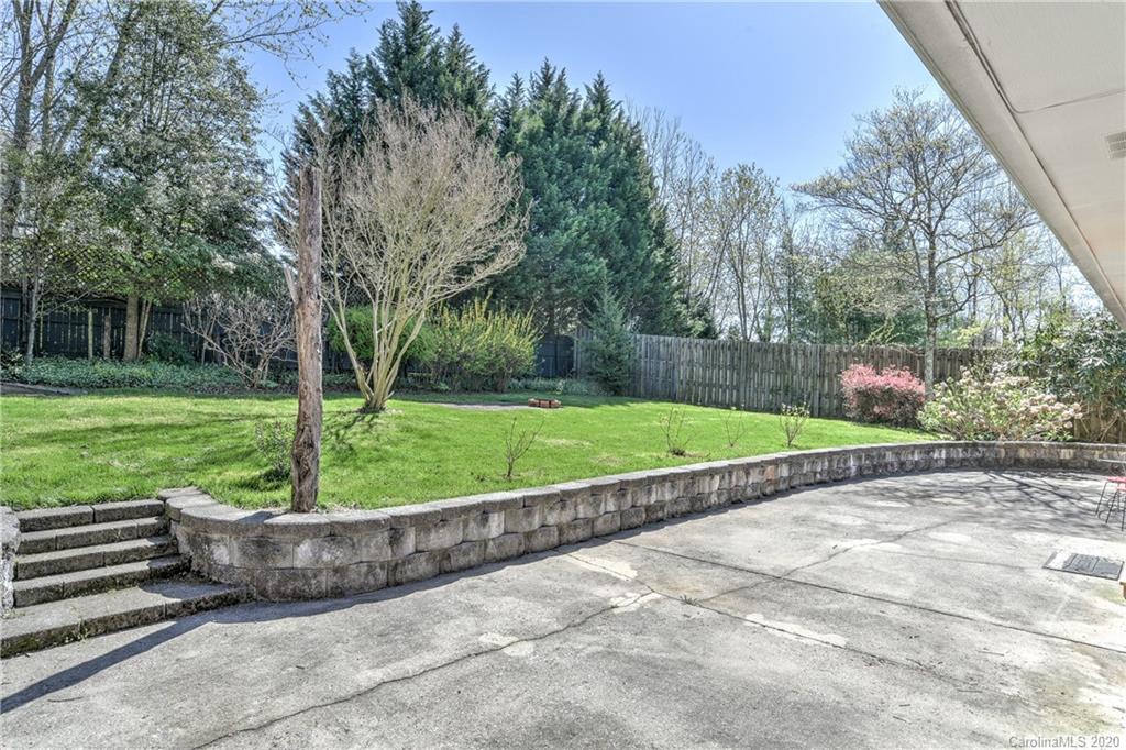 215 Rutledge Drive Hendersonville, NC 28739 - Photo 31 of 31 a view of a garden with a bench in a patio