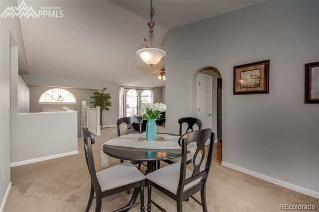6150 Rabbit Ears Court Colorado Springs, CO 80919 - Photo 12 of 31 a view of a dining room with furniture and a chandelier