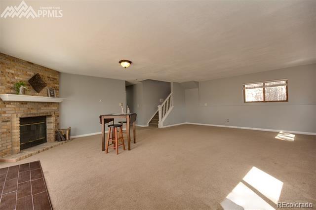 6150 Rabbit Ears Court Colorado Springs, CO 80919 - Photo 21 of 31 a living room with furniture and a fireplace